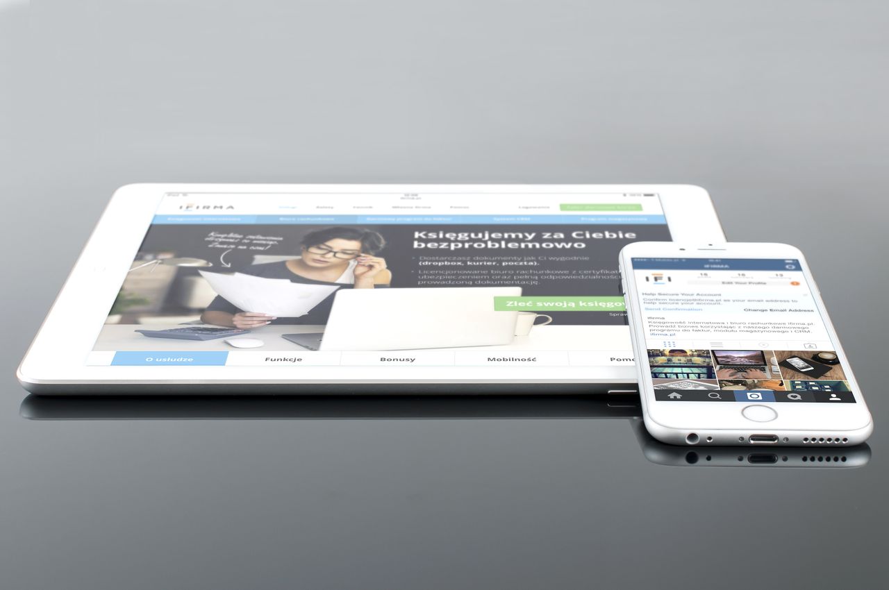 who-we-are Modern tablet and smartphone displaying web content on a reflective surface, highlighting technology and connectivity.